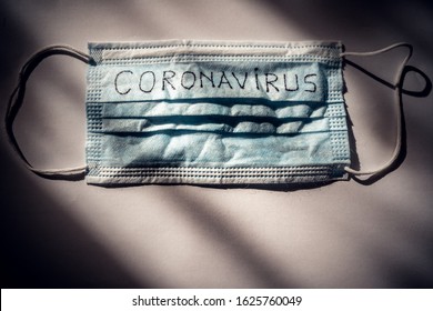 
Dramatic atmosphere with disposable surgical mask with coronavirus text written on it.2019-nCoV virus infection in Wuhan city. Covid-19 (SARS-CoV-2) spread around the world. Impact of pandemic virus.