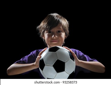 Dramatic Back-lit Boy With Soccer Ball On Black Background