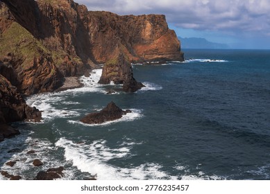 Dramatic basalt cliffs plunge into turquoise Atlantic waters with white-capped waves crashing against rocky outcrops. Stunning coastal