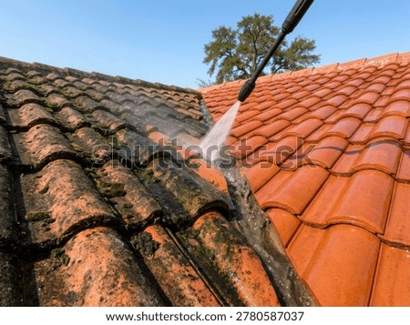 Dramatic before and after view of a red tiled roof being expertly pressure washed, revealing a clean, vibrant surface on a sunny day.