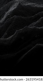 Dramatic black and white abstract image of textured, undulating surfaces resembling dark, rocky terrain or a deep, shadowy landscape. Perfect for backgrounds or design elements.