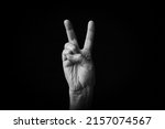 Dramatic black and white image of British Victory Hand emoji isolated on black background