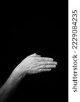 Dramatic black and white  image of a male hand fingerspelling the Fench sign language letter 