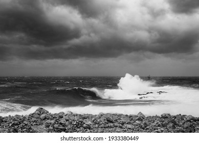 A dramatic black and white image showing big waves hitting the lighthouse. Photographed in Croatia near Rogoznica on Cape Punta Planka, December 2020