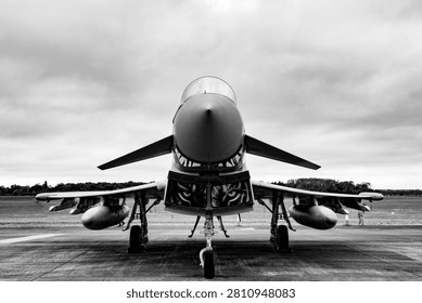 Dramatic black and white, low-angle, centered view of a powerful Eurofighter Typhoon fighter jet.