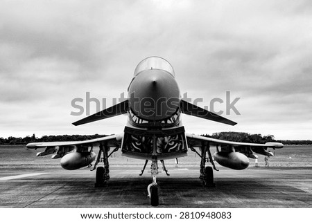 Dramatic black and white, low-angle, centered view of a powerful Eurofighter Typhoon fighter jet.
