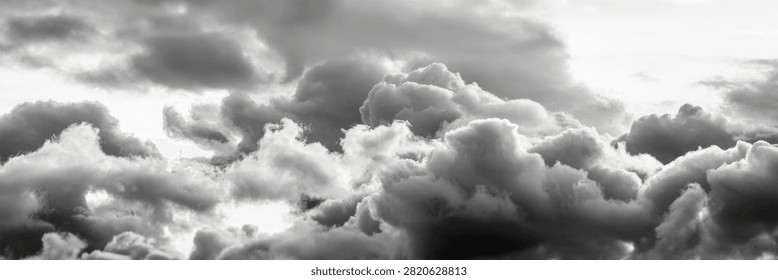 Dramatic black and white monochrome clouds fill the sky, creating a powerful and vast cloudscape.