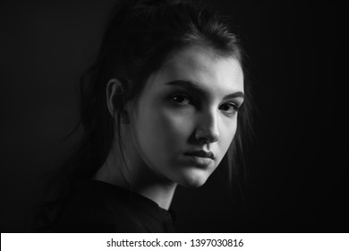 Dramatic Black And White Portrait Of A Beautiful Girl On A Dark Background