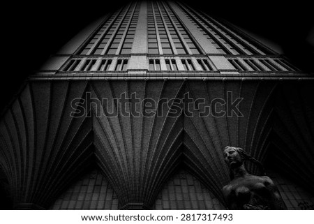 Dramatic black-and-white low-angle view of the Daido Life Osaka Head Office Building, showcasing its distinctive ribbed brick vaults and arched base, with a classical bronze statue of a woman in the foreground.