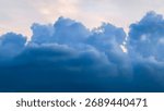 Dramatic blue clouds fill the frame, contrasting with a pale sky.