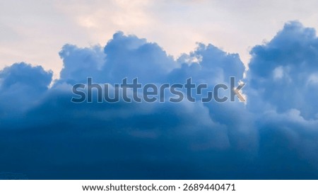 Dramatic blue clouds fill the frame, contrasting with a pale sky.