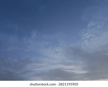 A dramatic blue hour sky captured during twilight, featuring a deep indigo backdrop layered with thick, dark clouds. The heavy cloud cover appears dense and sombre, creating a strong contrast against the cool blue tones of the fading daylight. This atmospheric scene is characteristic of the evening transition known as the “blue hour,” offering a moody and cinematic skyline.