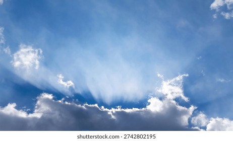 Dramatic blue sky background with sun rays shining through clouds and wide copy space. Clean cloudscape ideal for website headers, web banners, presentation slides and modern advertising design.
