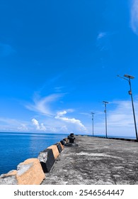 Dramatic blue sky and Cumulus clouds in the horizon meet calm and deep blue sea