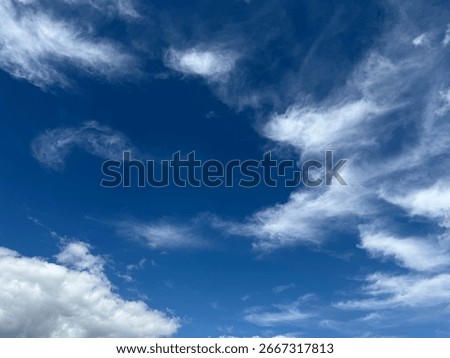 Dramatic blue sky filled with white and golden clouds, creating a dynamic and vast natural background.