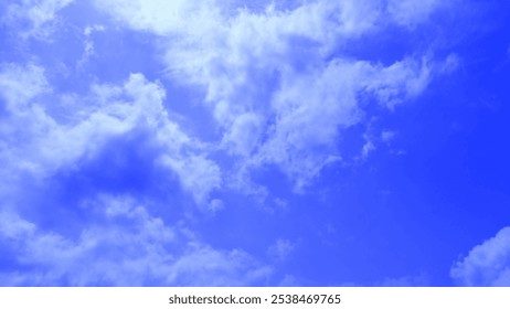 Dramatic blue sky with fluffy white clouds, creating a dynamic and textured background.