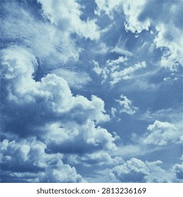 Dramatic Blue Sky with Fluffy White Clouds and Vintage Film Grain Texture.An atmospheric and dramatic sky filled with thick, textured white clouds against a deep blue background. The illustration features a stylized, retro photographic style with a subtle film grain overlay, perfect for creative backgrounds, moody designs, and artistic album covers.
