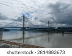 Dramatic cable-stayed bridge spans the Fraser River under heavy clouds in Greater Vancouver, British Columbia, Canada.