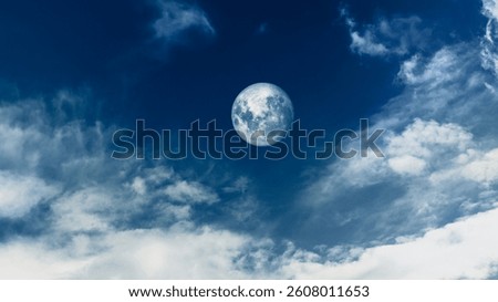 Dramatic calm silent dark blue sky and full moon. Moon rising among clouds at night.