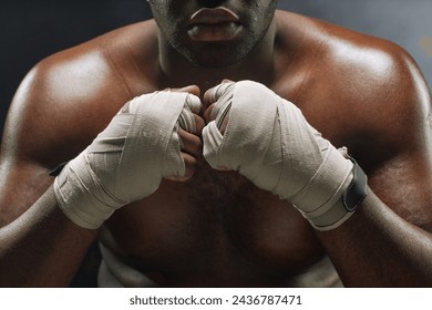 Dramatic close up of African American fighter with hands wrapped in bandages - Powered by Shutterstock