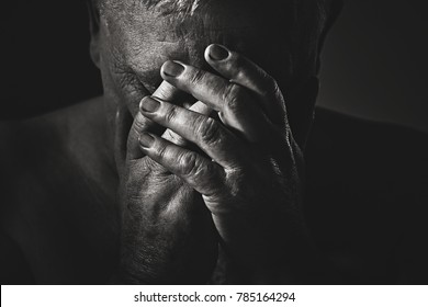 Dramatic Close Up Black And White Portrait Of Depressed Old Man With Hands On Face