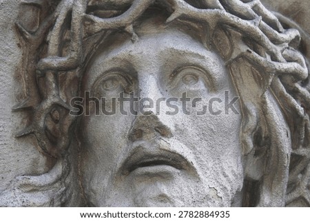 Dramatic close up of Jesus Christ statue with crown of thorns, symbolic image of suffering and sacrifice