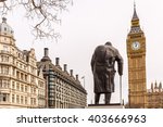 Dramatic close view of Big Ben framed by a dark statue silhouette in Westminster London; ideal for travel marketing, editorial layouts, tourism ads and heritage branding