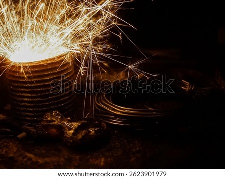a dramatic close-up of bright sparks flying from a metal object in a dark industrial setting, surrounded by coiled cables and rugged tools, capturing the intensity of heavy-duty work.

