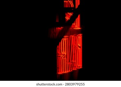 Dramatic close-up of glowing red neon sign spelling DAVID against deep black night background. Moody and cinematic lighting perfect for urban night vibes
