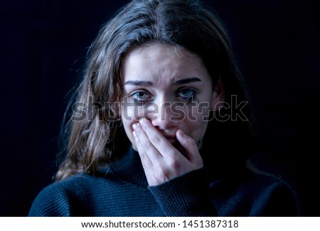 Dramatic closeup portrait of young scared, depressed girl crying alone, feeling hopeless suffering from harassment or domestic violence. Stop child abuse and neglect. Social campaign concept.