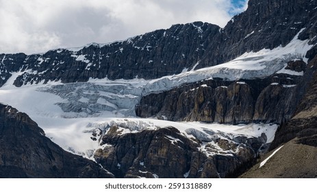 A dramatic close-up of rugged mountain cliffs adorned with glacial ice, revealing the power and resilience of nature in its most formidable form.