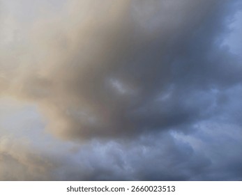 Dramatic cloud formation highlights changeable weather over a tranquil landscape at sunset. High quality photo