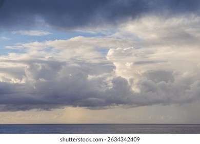 Dramatic cloud formations over the Pacific Ocean under a peaceful twilight overlooking the horizon.
