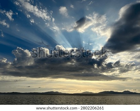 A dramatic cloud pierced by the sun's rays over the Ionian Sea