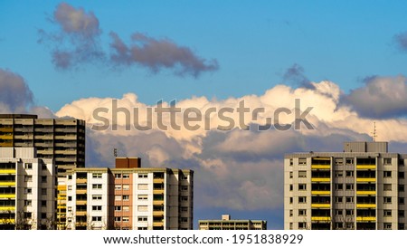Dramatic clouds in blue sky behind city buldings