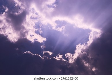 Dramatic clouds frame with sunlight rays on twilight blue sky background. Aesthetic of natural fluctuation in high sky atmosphere.