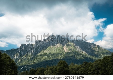 Dramatic clouds hide Monte Due Mani above the Lombardy mountain landscape, ideal for travel