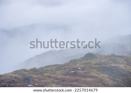 Dramatic clouds in the Lake District National Park in England on a moody day with grey skies. Taken from Tarn Crag near Easedale. 