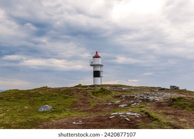 Dramatic clouds loom over the iconic Borhella lighthouse, an emblematic structure guiding seafarers in Northern Norway