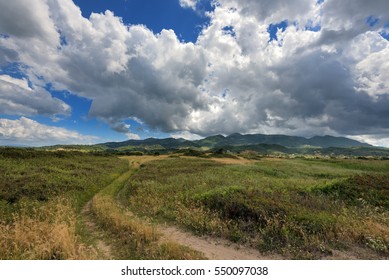 Dramatic clouds over the fields and mountains near the beach in Acharavi village. Corfu island, Greece.