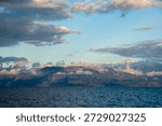Dramatic clouds over mountain, across water in Peloponnese, Greece