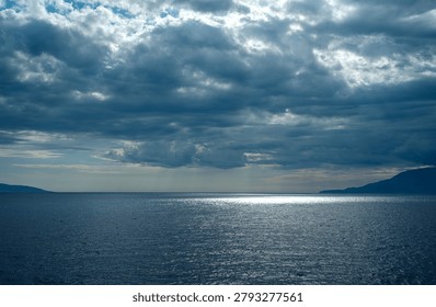Dramatic clouds over the sea, sunbeams breaking through the horizon, between Kyllini and Poros