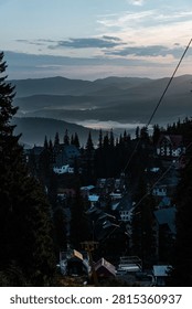 Dramatic clouds rolling over a forested mountain ridge