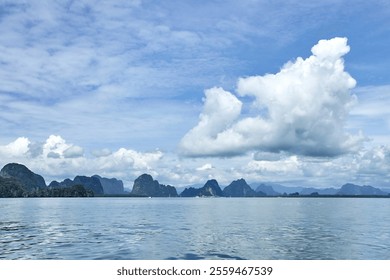 Dramatic clouds and serene seascape with limestone islands under blue sky in tropical environment. - Powered by Shutterstock