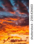 Dramatic clouds at sunset or sunrise. Vibrant orange clouds at sunset vertical photo.