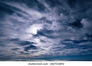 Dramatic cloudscape with light clouds covering the whole frame in a bizarre pattern
