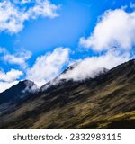 Dramatic cloudscape over the Chugach Mountains in Anchorage, Alaska, a summer morning landscape view from Glen Alps Hiking Trail, with a hanglider flying in the air