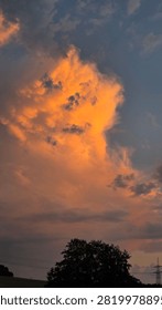 Dramatic cloudscape over farmland at sunset