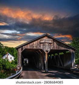 Dramatic cloudscape over the historic landmark Pulp Mill Covered Bridge, Vermont’s oldest surviving covered bridge built in 1808 and 1820, spanning the Otter Creek in Middlebury, Vermont, USA