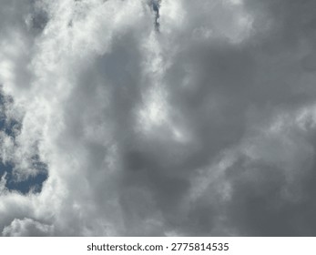 Dramatic cloudscape with sunlight breaking through layered storm clouds creating moody sky atmosphere and natural weather contrast